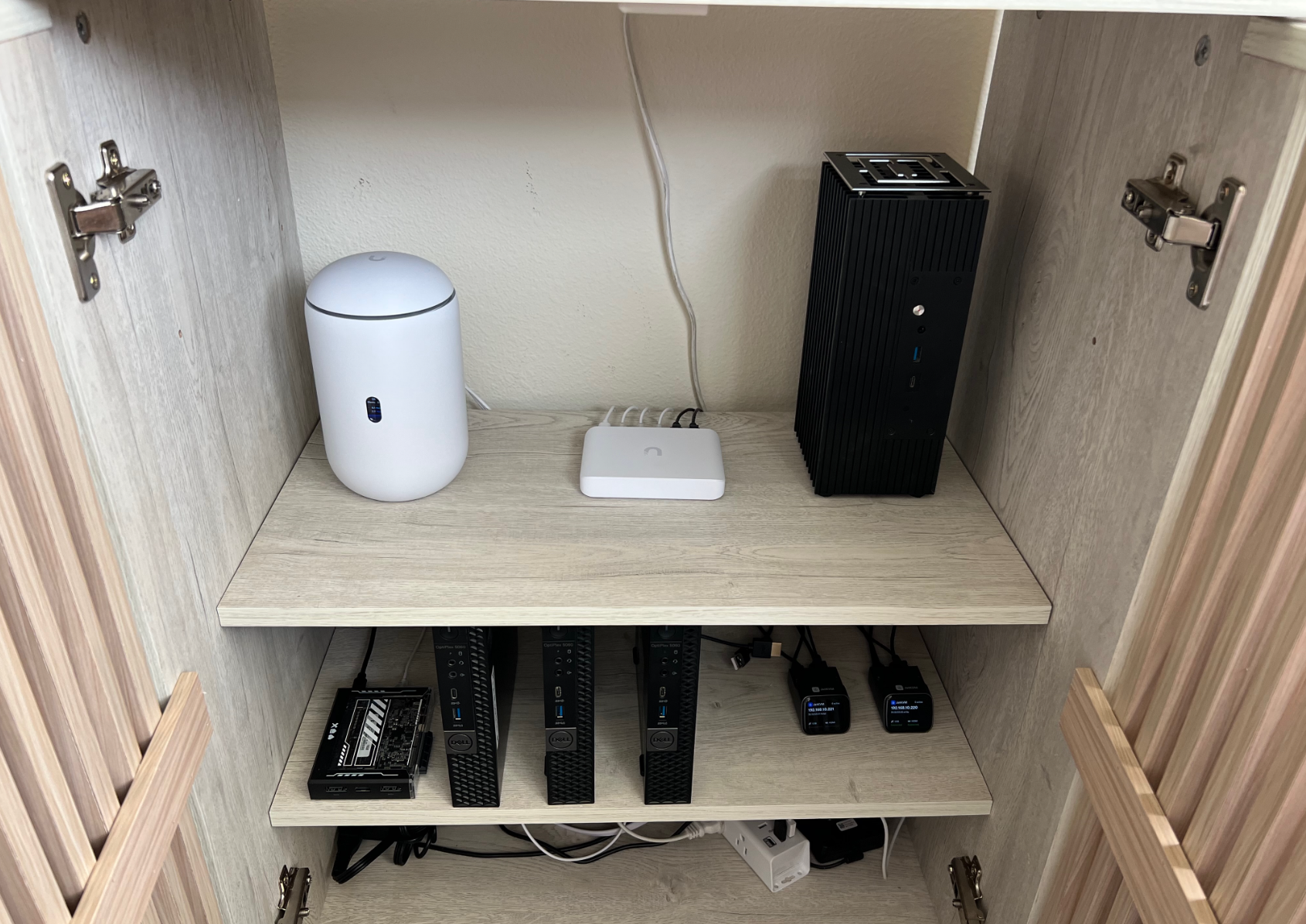 Behind the wooden doors: networking gear, several small systems — and a ZimaBlade tucked into the lower shelf.